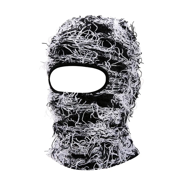 Gros plan d'un bonnet balaclava tricoté délavé noir et blanc avec une découpe pour le visage.