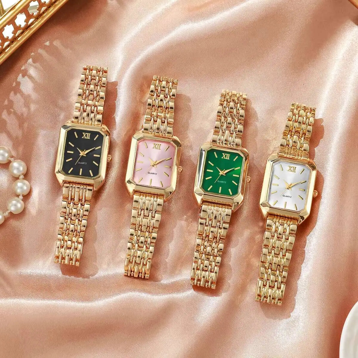 Colección de cuatro elegantes relojes analógicos de cuarzo con eslabones tono oro y diferentes caras de colores, mostrados en