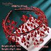 A close-up of a red rhinestone bridal headband featuring delicate leaves and berries.