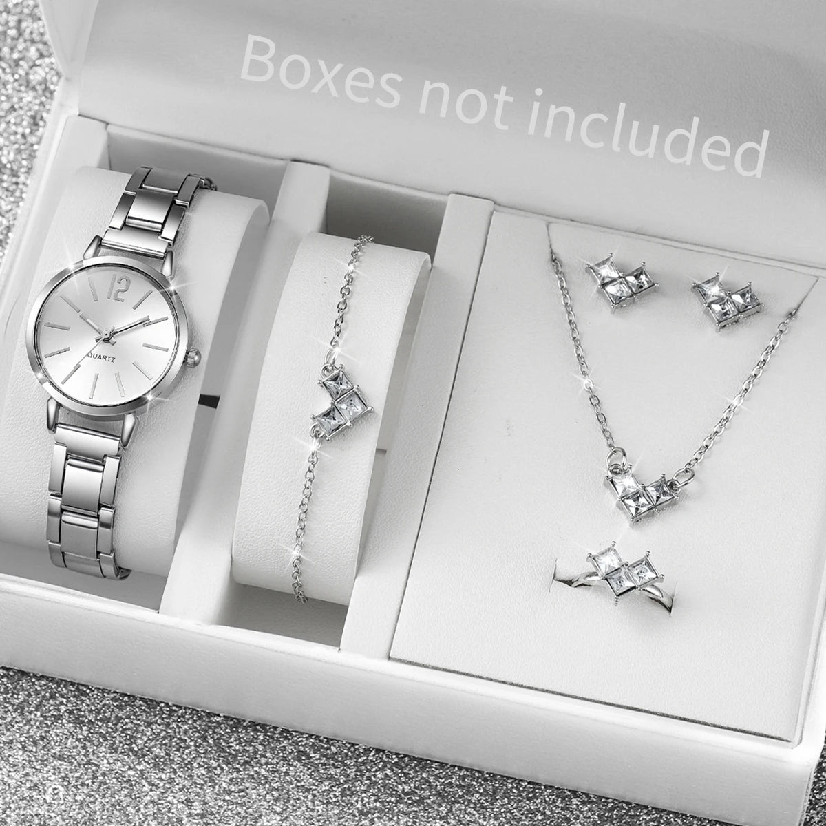 A white box shows an elegant quartz wrist watch, a silver necklace, and diamond earrings.