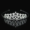 Tiara y corona de princesa de cristal brillante para el cabello, mostrada en una superficie reflectante.