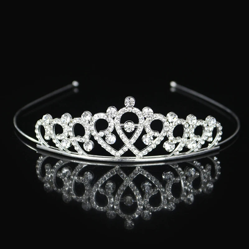Tiara y corona de princesa de cristal brillante para el cabello, mostrada en una superficie reflectante.