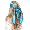 Eine Frau trägt einen blau-goldenen Boho-Seidenschal als Kopftuch