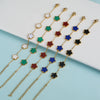 Un juego de pulseras florales de acero inoxidable chapado en oro con flores de esmalte en blanco, verde, rojo y azul.