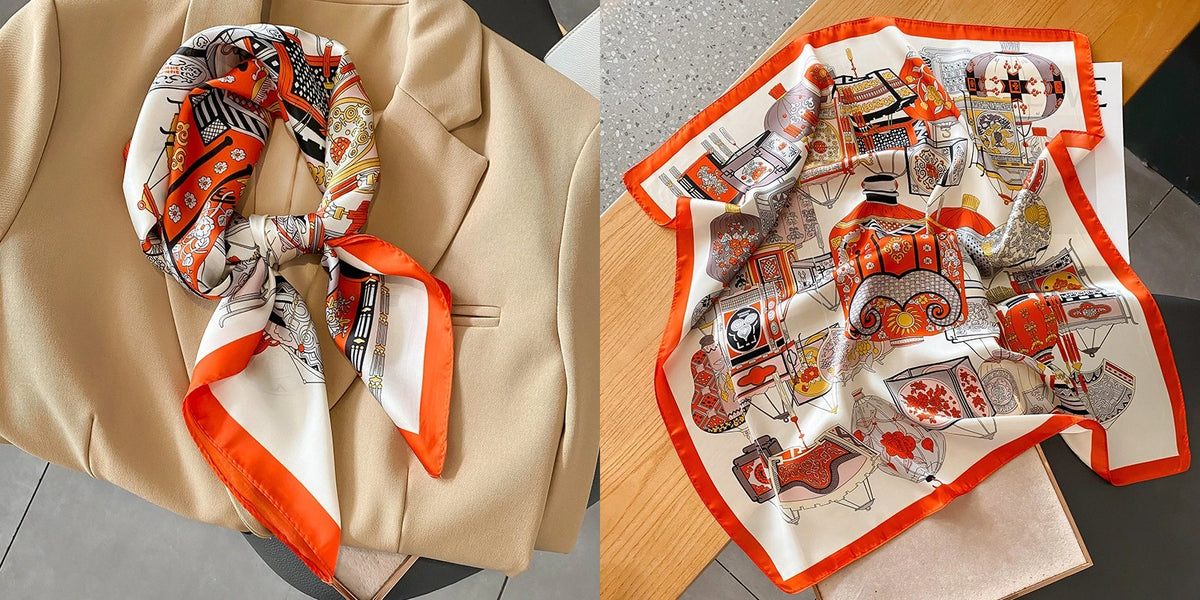 A floral print silk scarf featuring orange and white patterns is displayed on a beige blazer.