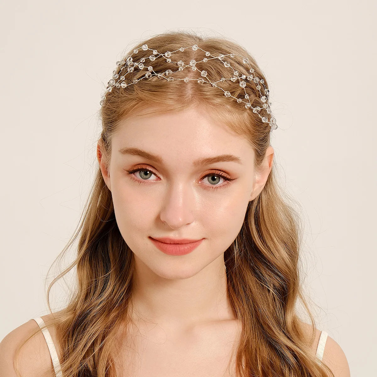 A young woman with long blonde hair wears an elegant pearl hair net headband.