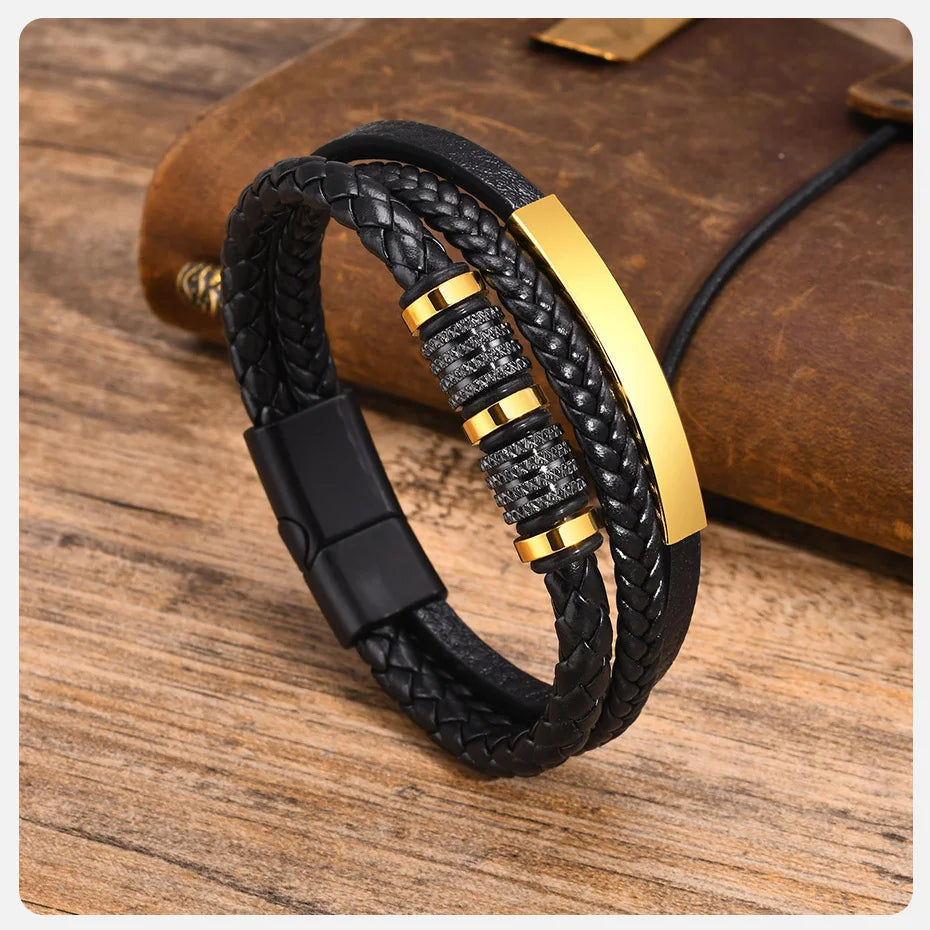 Schwarzes geflochtenes Lederarmband mit goldenen Akzenten auf einer Holzoberfläche