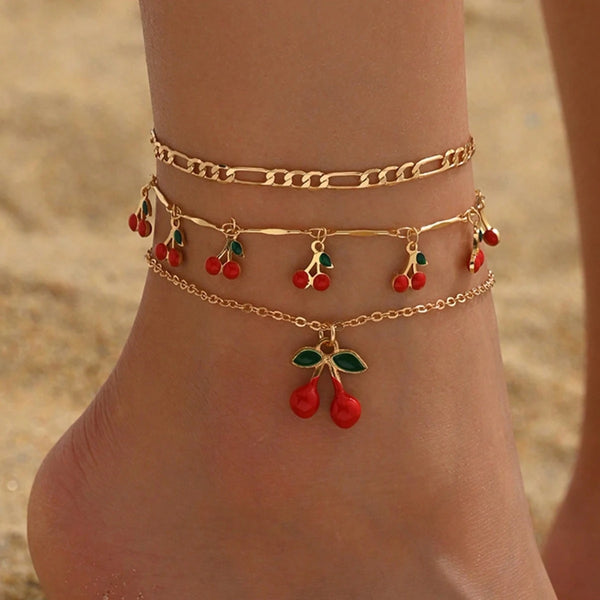 Chaîne de cheville dorée avec des perles de riz cerises rouges et vertes.