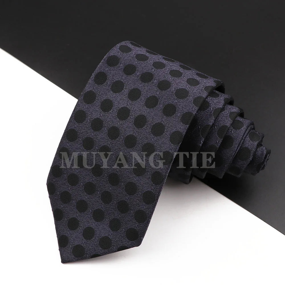 Dunkelgraues oder schwarzes Seidkrawatt mit dezenter Polka-Dot-Muster, gefaltet und auf weißem Hintergrund.