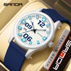 A white and blue digital watch with a dark face and blue accents is displayed on a beige leather surface.