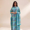 A woman models an elegant long silk blend cover-up robe dress featuring a vibrant blue and teal pattern of interconnected cir