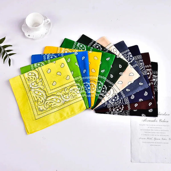 A set of colorful bohemian print bandanas and wrist wraps arranged on a white surface.