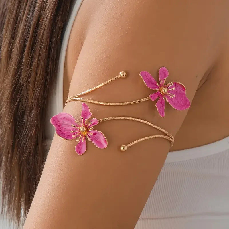 Gold floral open cuff armlet jewelry worn on a person's arm.