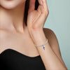 A close-up of a woman's wrist wearing a sterling silver devil's eye charm bracelet.