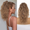 Gros plan sur de longues extensions de cheveux blonds ondulés, stylées avec une texture bouclée volumineuse.