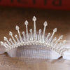 A sparkling crystal princess tiara hair comb for women displayed on a wooden surface.