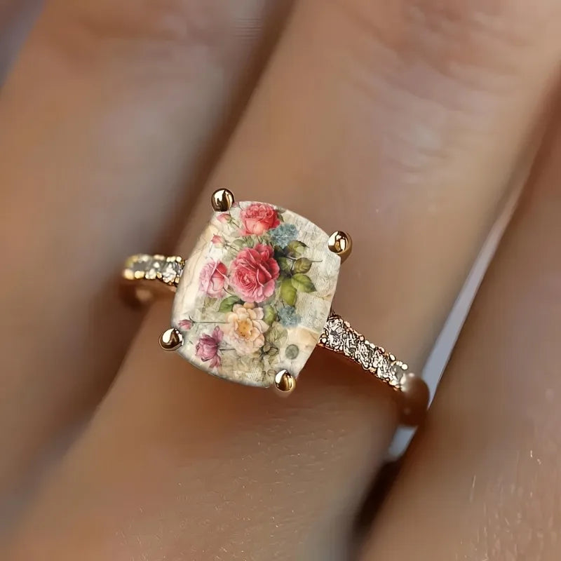 Bague en or avec une pierre cabochon illustrant une rose rétro et de petits diamants pavés.