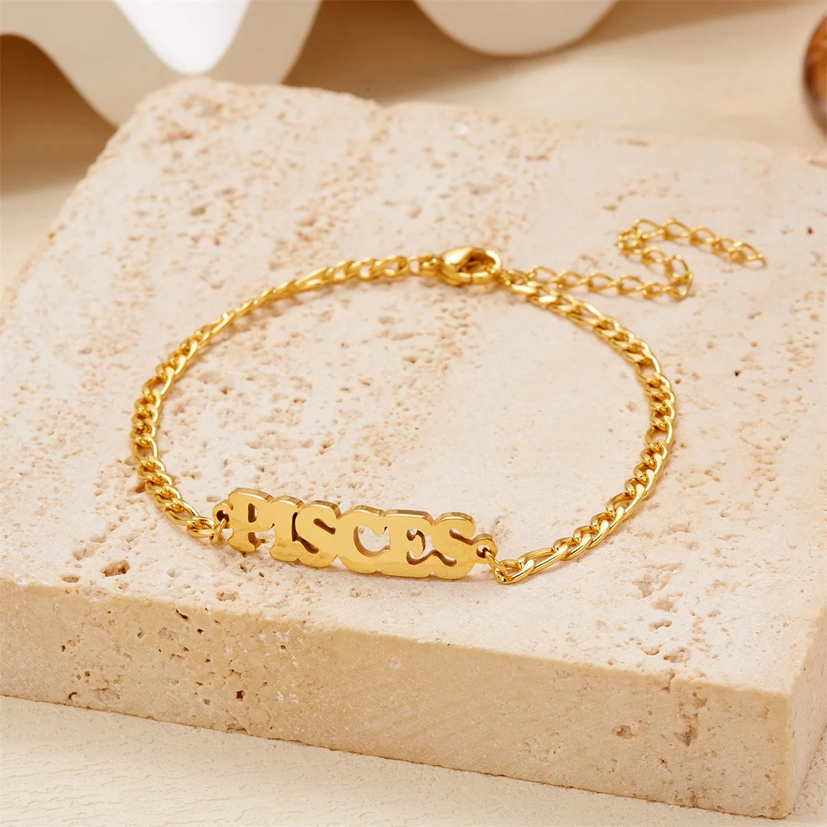 Gold stainless steel zodiac constellation charm bracelet with the word Pisces engraved on it