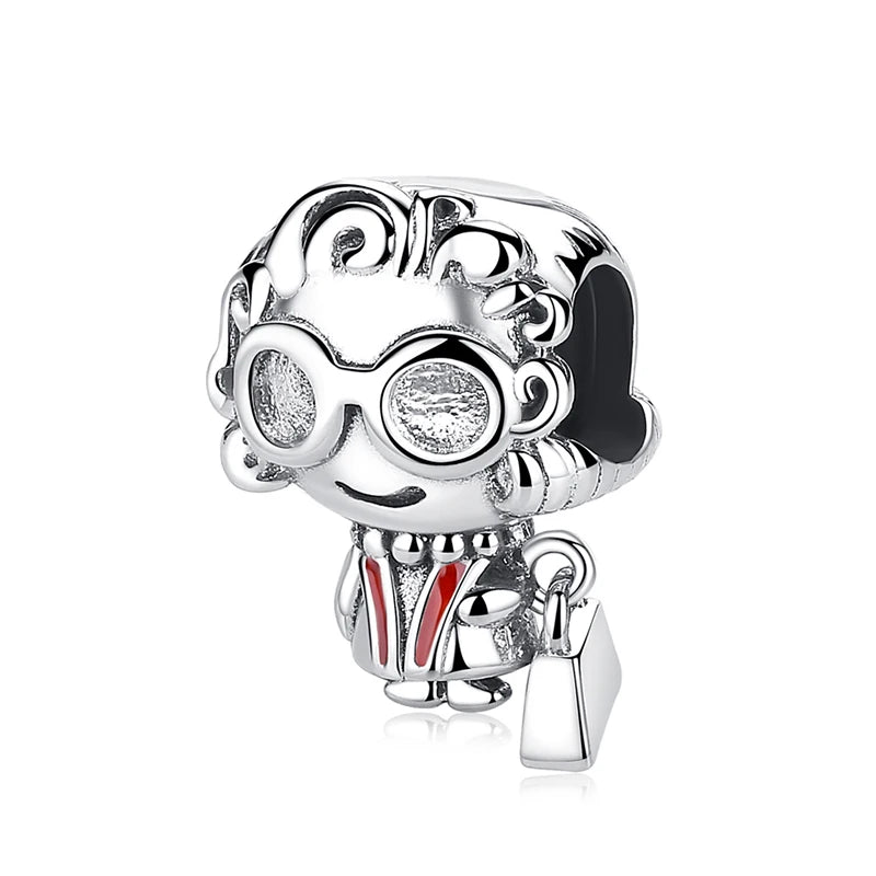 A silver family tree charm jewelry piece featuring a stylized face wearing round glasses and a red and white striped shirt.