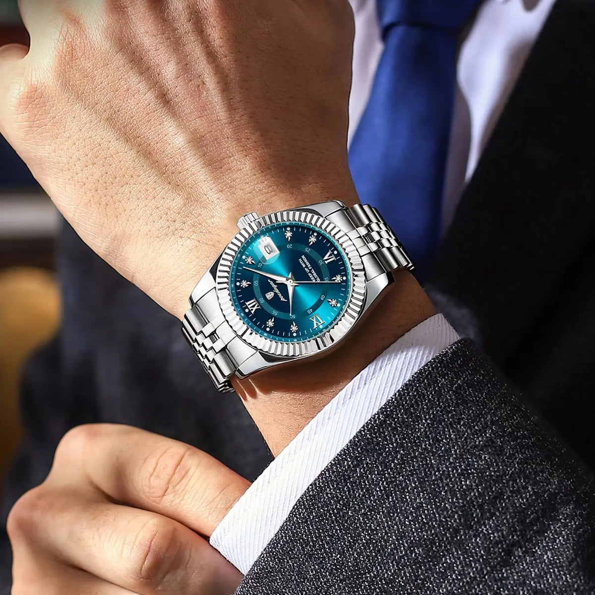 Gros plan d'une montre-bracelet en quartz argentée luminescente portée sur un poignet, associée à une manche de costume sombr