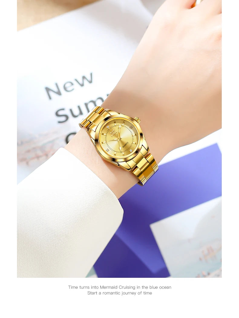 A close-up of a gold-toned luminous quartz watch worn on a wrist, with blurred text in the background.