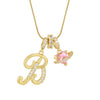 A gold letter P pendant necklace with a pink gemstone charm on a delicate chain.