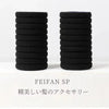 A stack of black elastic hair ties for ponytails and buns.