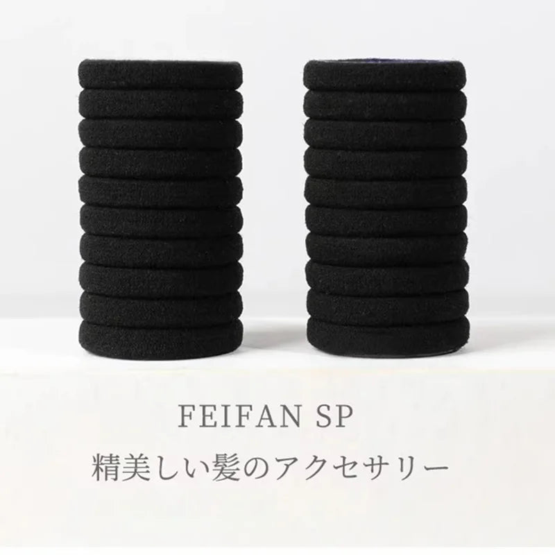 A stack of black elastic hair ties for ponytails and buns.