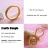 A close-up of a new arrival gold plated elastic bangle bracelet on a pink background.