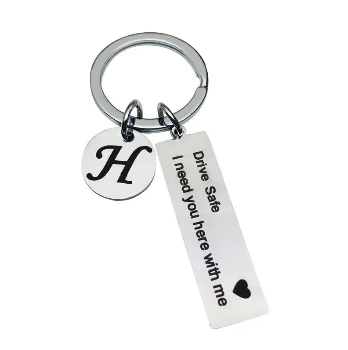 Silver keychain with a circular initial H charm and a tag that reads Drive Safe I need you here with me