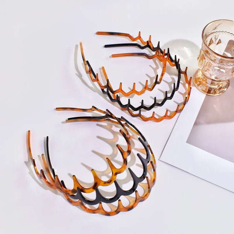 A set of textured hair bands in shades of orange and black arranged on a white background.