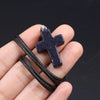 Ein dunkelblau gesprenkeltes Tigerauge-Agat-Kreuz-Anhänger-Armband in der Hand.
