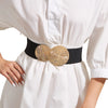 A white dress or coat features a black elastic waist belt adorned with a gold woven decorative buckle.