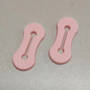 Un par de hebillas ajustables para extensiones de manga de camisa rosa.