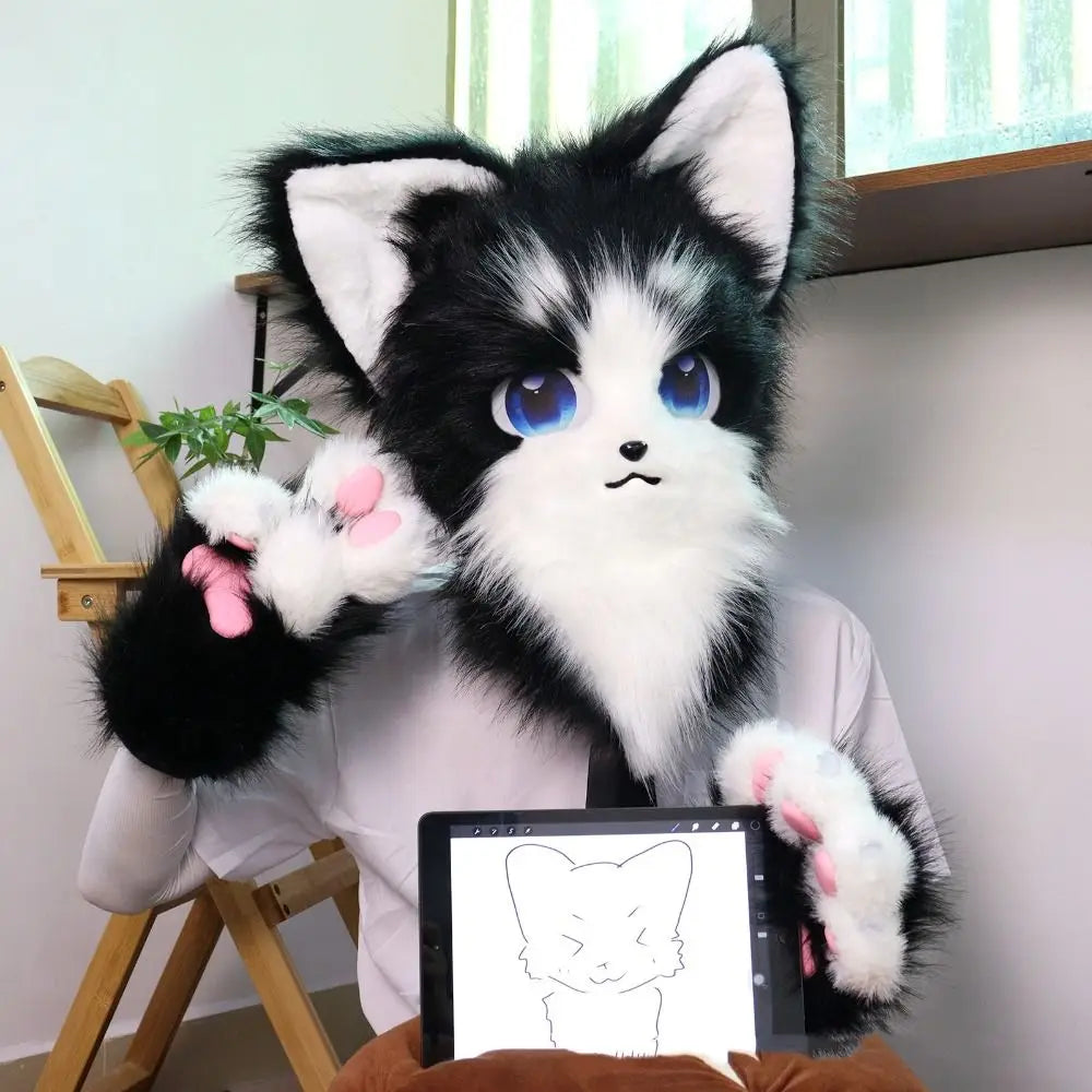 A black and white cartoon fox plush toy wearing furry gloves sitting on a wooden chair.