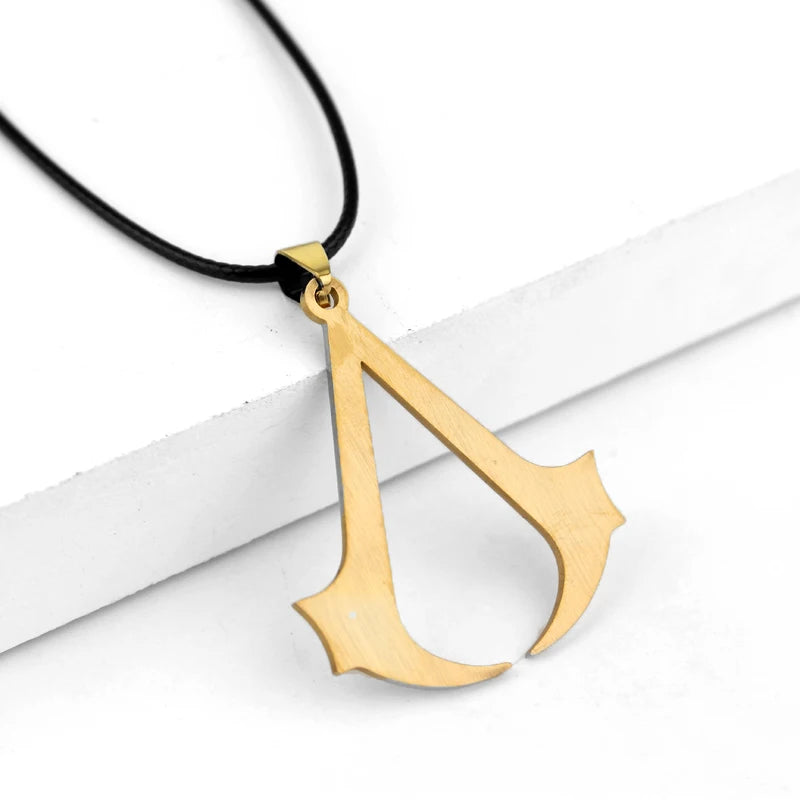 A gold-toned stainless steel pendant necklace shaped like the letter A, featuring a black cord.