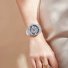 Gros plan d'une montre en quartz de luxe avec un cadran serti de diamants argentés et noirs, portée au poignet.
