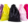Five satin wig storage bags in purple, yellow, black, pink, and magenta with drawstrings.