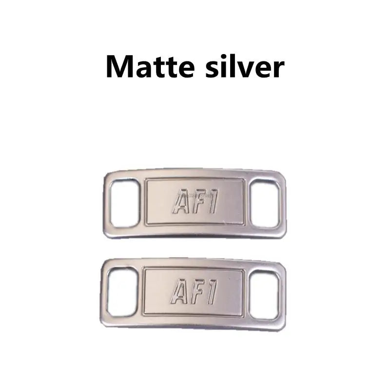A pair of matte silver AF1 diamond shoe charms and laces.