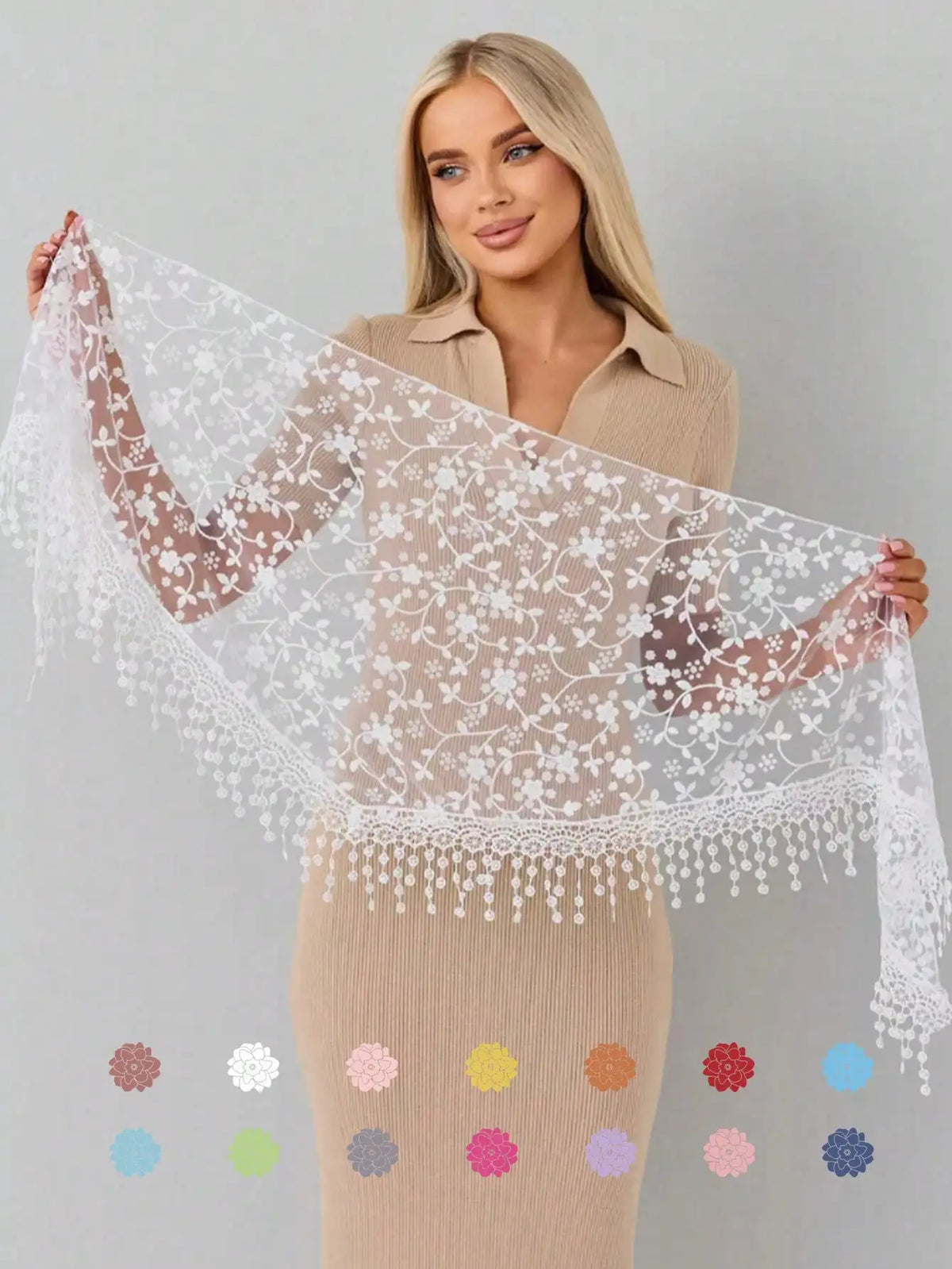 A woman models a sheer floral lace scarf draped over her arms, paired with a beige knit dress.