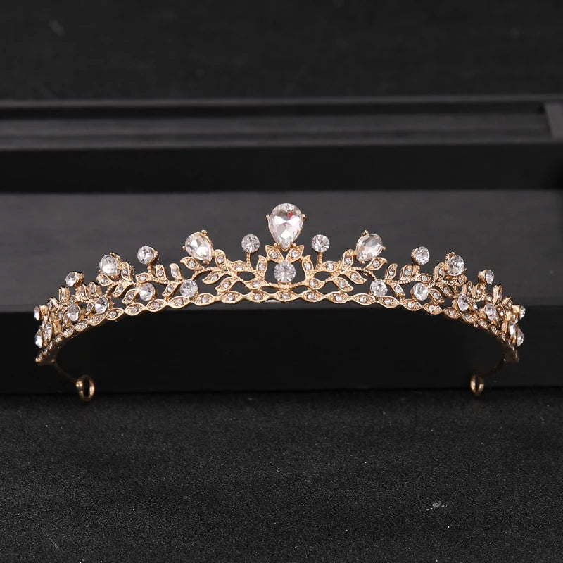 Gold-toned Baroque crystal rhinestone bridal tiara headpiece displayed on a black surface.