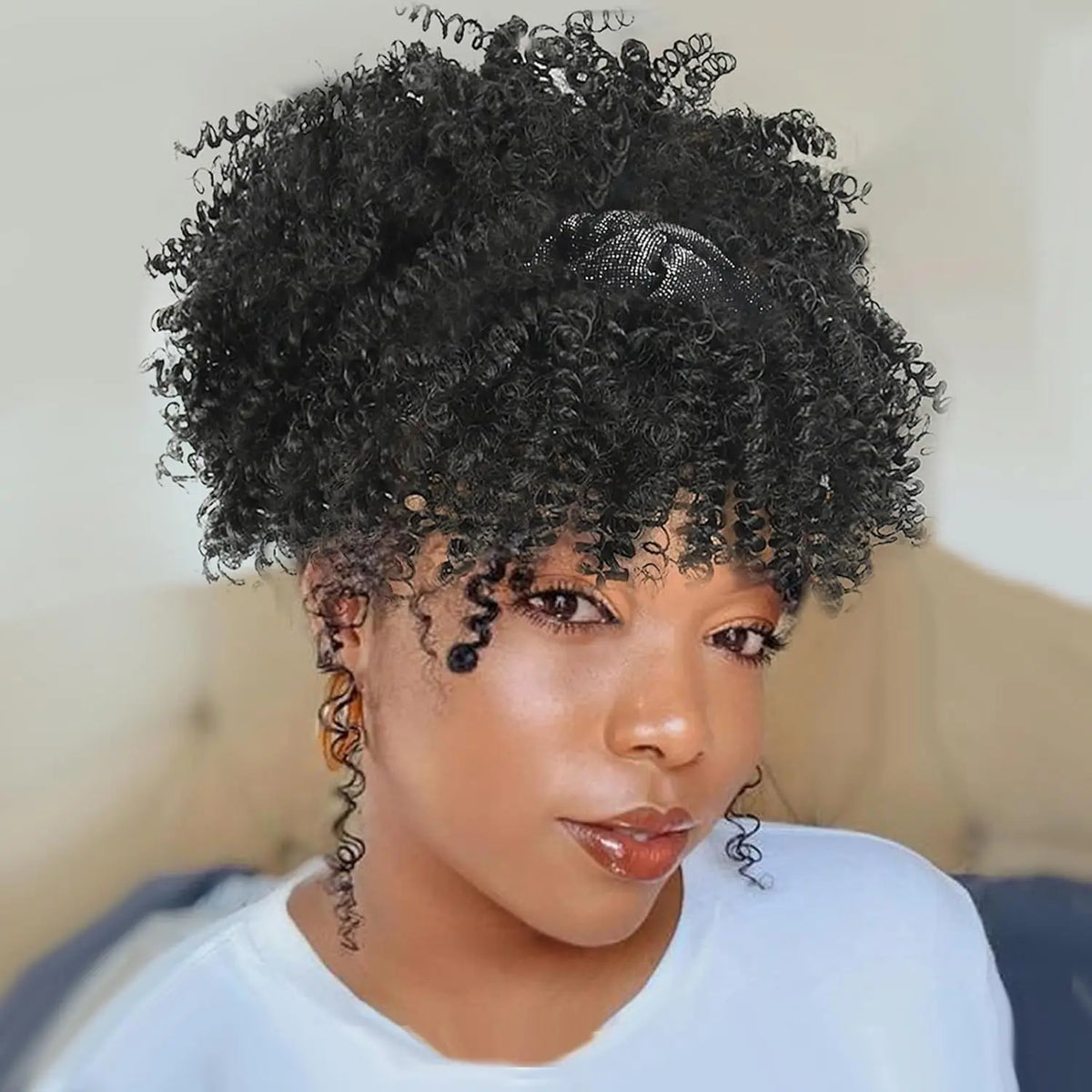 Primer plano de una mujer usando una peluca afro rizada y encrespada negra con una diadema.