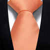 Nahaufnahme einer orange gemusterten Krawatte, getragen gegen eine schwarze Sakkojacke.