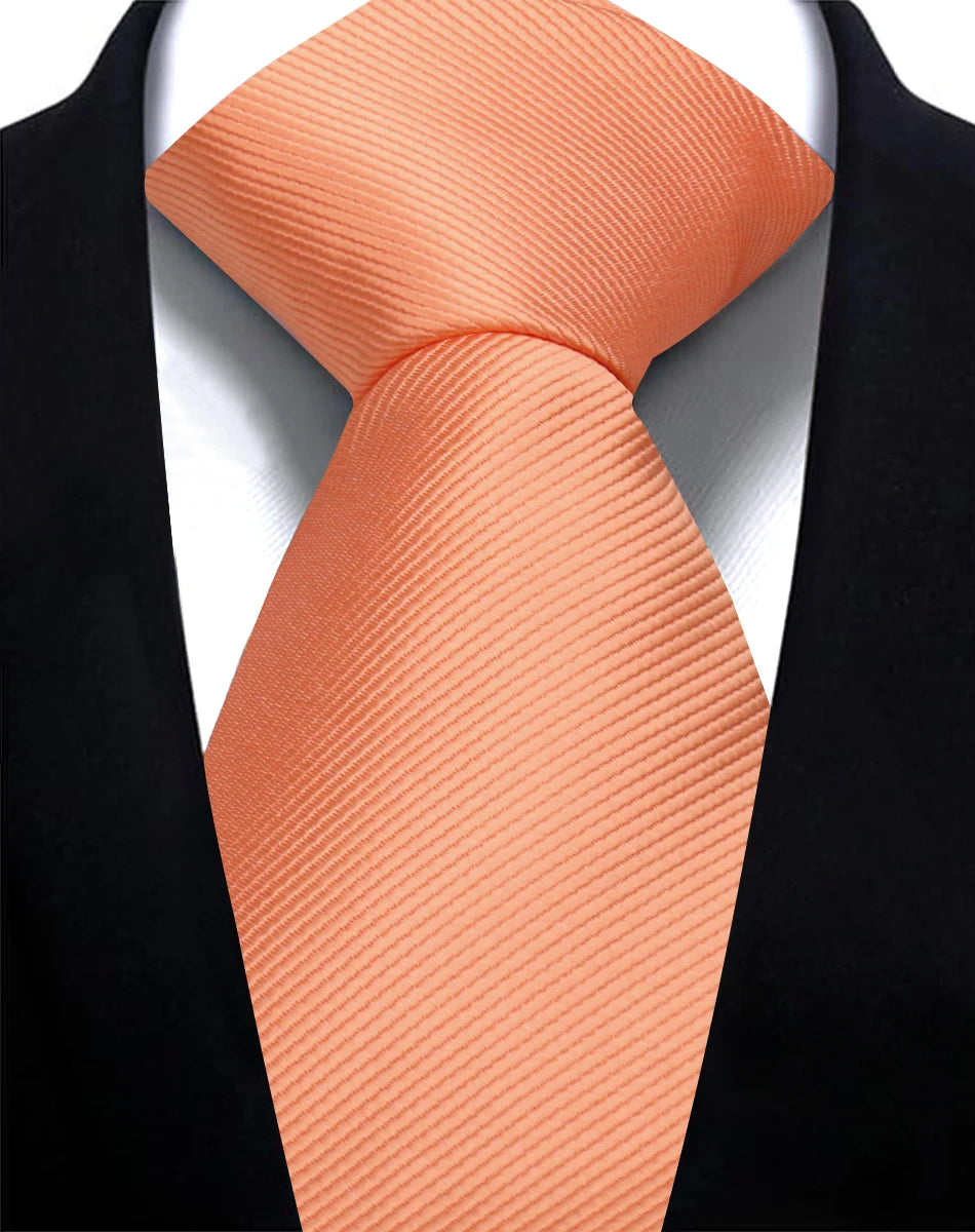 Nahaufnahme einer orange gemusterten Krawatte, getragen gegen eine schwarze Sakkojacke.