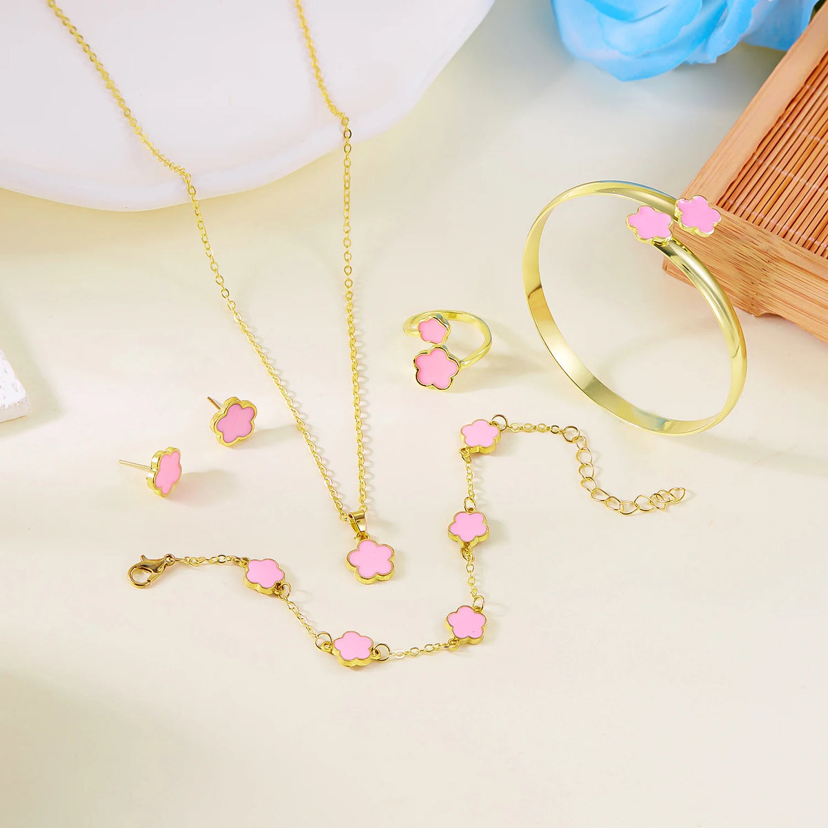 A set of five gold-toned bracelets featuring pink enamel plum blossoms displayed on a light background.