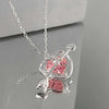 Silver heart pendant necklace featuring a pink zircon stone and a clear bar design.