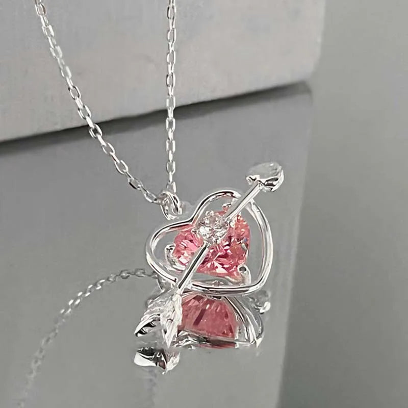 Silver heart pendant necklace featuring a pink zircon stone and a clear bar design.