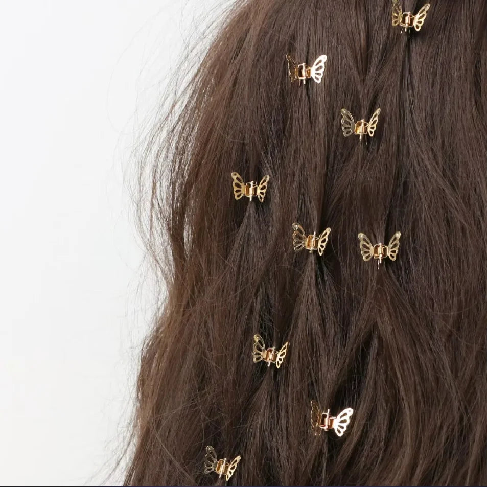 A close-up of dark brown hair adorned with ten small gold metal butterfly hair clips.