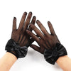 Black mesh finger gloves with satin bows shown on a hand.