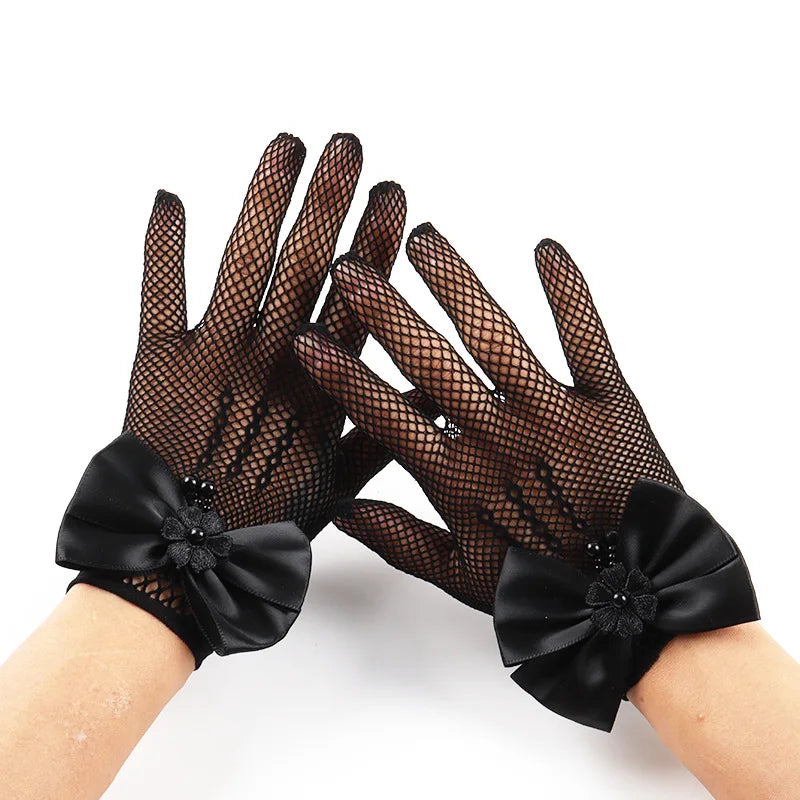 Black mesh finger gloves with satin bows shown on a hand.